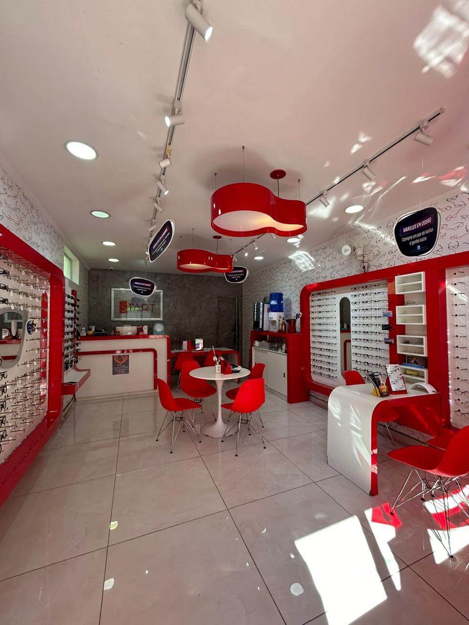 Visão interna da Ótica Start Albion com balcão e expositores de óculos